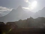To Gokyo 1-1 Ama Dablam At Sunrise From Khumjung After an early breakfast, I passed the Mani wall and again chanted �Om Mani Padme Hum�, and �Buddha please show me the right way�. I headed off on the path towards my next stop in Dole. The sun shone over Ama Dablam, silhouetting a few early rising trekkers. After walking a few minutes I passed an old woman leading her sheep. I walked past her. She yelled at me. I stopped, looked at her, and continued walking. She yelled again and tugged my arm. She motioned down the hill I was ascending.  I said, �Gokyo?� and pointed up the trail. She simply pointed down the hill. I finally got it through my brain that she was telling me I was on the wrong trail. I waved at her and walked down the hill and took the first trail hugging the hillside. I started walking. I heard another sound from above. I looked up and saw the same woman yelling again. I stopped and she stopped. I started walking slowly, and she started yelling again. I turned around and walked down to the next path that went in the opposite direction. This time the woman remained silent. I yelled �Thank you�, waved and continued walking.